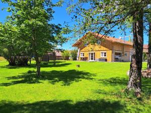 a house in a field with trees in the foreground at Ferienhaus Eichenstein in Meßstetten