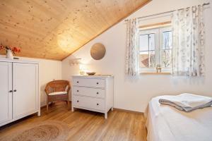 a bedroom with a bed and a dresser and a window at Ferienhaus Eichenstein in Meßstetten