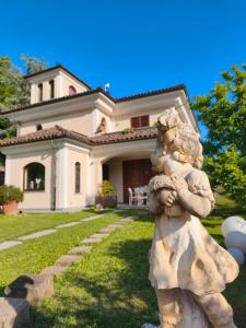 a statue in front of a house with a building at B&B Montisclari in Monchiero