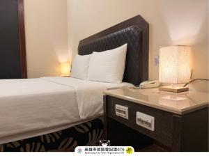 a hotel room with a bed and a telephone at I HI Sanduo Travel Hotel in Kaohsiung +105 photos