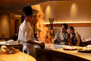 a man standing in a kitchen with a chef at Conrad Bangkok in Bangkok