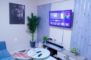 a living room with a tv and a couch and a table at Benson waweru APPARTMENT in Kakamega