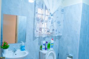 a bathroom with a sink and a toilet and a mirror at Benson waweru APPARTMENT in Kakamega