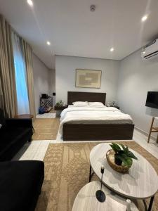 a bedroom with a bed and a living room at Modren AD 23 in Dammam