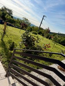 a wooden bench next to a field of grass at Valmaris in Râmnicu Vâlcea +9 photos