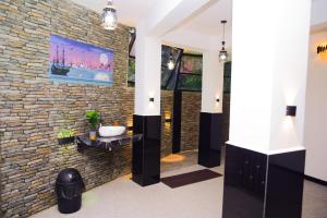 a bathroom with a stone wall with a sink at Thenulya Resort in Ella