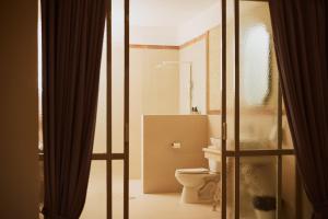 a bathroom with a toilet and a sliding glass door at Spiegel Home Studio in Semarang