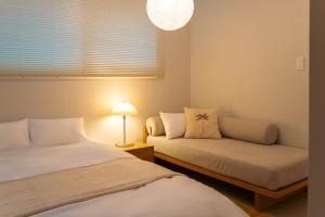 a bedroom with two beds and a couch and a lamp at 가치스테이 강서 in Seoul