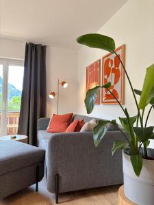 a living room with a couch and a plant at Alpensegler in Mittenwald