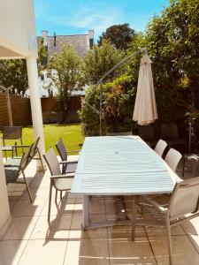 a blue table and chairs and an umbrella on a patio at Location maison 2 chambres in Carnac