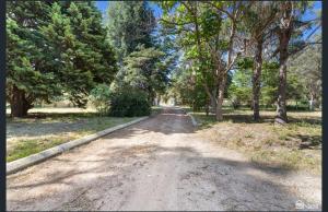 an empty road with trees on the sides of it at Room in a shared farmhouse in Kelmscott
