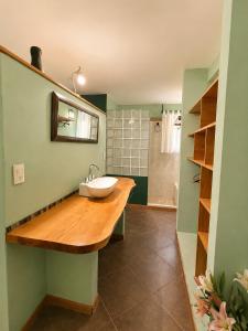 a bathroom with a wooden counter with a sink at Cabañas La Matera Apart in Los Reartes +28 photos