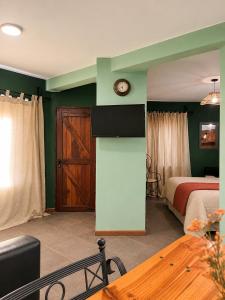 a bedroom with a bed and a clock on the wall at Cabañas La Matera Apart in Los Reartes