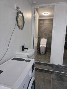 a white bathroom with a toilet and a sink at Room in a shared farmhouse in Kelmscott +20 photos