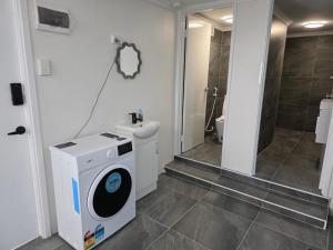 a bathroom with a washing machine and a sink at Room in a shared farmhouse in Kelmscott
