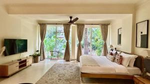 a bedroom with a bed and a large window at SaffronStays Oslo in Anjuna