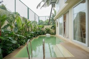 a swimming pool in a house with plants at SaffronStays Oslo in Anjuna
