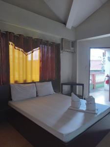 a bedroom with a large bed with towels on it at Central View Apartelle in Angeles