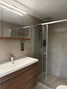 a bathroom with a sink and a shower at Almyra Suites in Khalíkia +25 photos