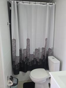 a bathroom with a toilet with a city shower curtain at Apartamento Céntrico y Equipado in Concepción