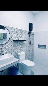 a bathroom with a white toilet and a sink at Rainbow River View in Jerantut
