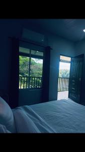 a bedroom with a bed and a view of a balcony at Rainbow River View in Jerantut +1 photo