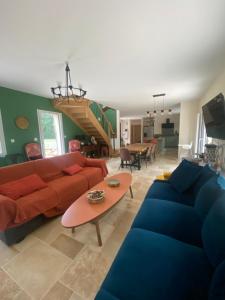 a living room with a red couch and blue couches at Le Cocooning in Asnières