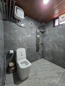 a bathroom with a toilet and a shower stall at River Portico in Tenmalai
