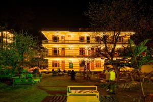 a lit up building with people in front of it at night at The Royal Pinewood in Kasol +10 photos