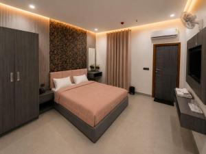 a bedroom with a large bed and a television at Hotel Golden Plaza in Amritsar