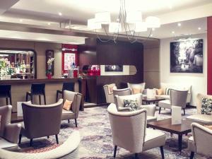 ein Wartezimmer mit Stühlen, Tischen und einer Bar in der Unterkunft Mercure Angers Centre Gare in Angers