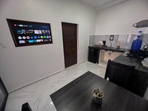 a dining room with a table and a tv on the wall at San Cristóbal Surf House lll in Puerto Baquerizo Moreno