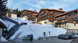 a man standing in front of a snow covered building at Les Brigues in Courchevel