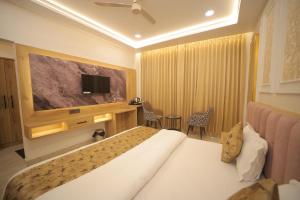 a hotel room with a bed and a flat screen tv at Baba Palace in Ayodhya +81 photos