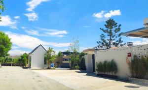 a white fence in front of a house at บ้านออมPool villa บางแสน om in Ban Bang Saen (1)