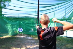 a young boy swinging a baseball bat in a batting cage at Camping Bella Italia in Peschiera del Garda