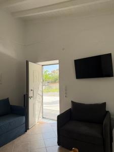 a living room with a couch and a flat screen tv at Almyra Suites in Khalíkia