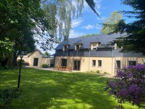 a large white house with a large yard at Le Cocooning in Asnières
