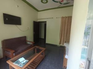 a living room with a couch and a tv at Hotel Swagat Sarovar in Pauri