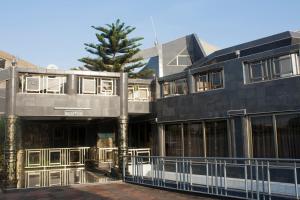 a building with a tree in front of it at Eastgate Hotel in Accra