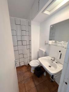 ein weißes Badezimmer mit Toilette und Waschbecken in der Unterkunft Hotel National in Mamaia + 27 Fotos