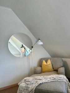 a room with a lamp and a chair with a yellow pillow at Spicīte in Ventspils