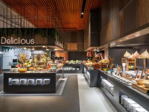 a restaurant with a buffet of food on display at Novotel Bangkok Platinum Pratunam in Bangkok
