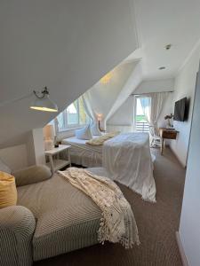 a attic bedroom with two beds and a couch at Spicīte in Ventspils