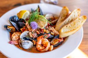 a plate of food with shrimp and mussels and bread at Hotel Restaurant Neu Meran in Bad Reichenhall
