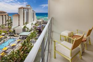 a balcony with a table and chairs and a view of the city at Ka Laʻi Waikiki Beach, LXR Hotels & Resorts in Honolulu