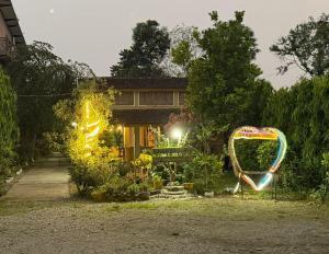 a house with a garden with a sign in front of it at Tamu Homestay in Jhawāni +4 photos