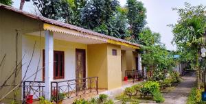 a yellow house with a balcony on the side of it at Tamu Homestay in Jhawāni