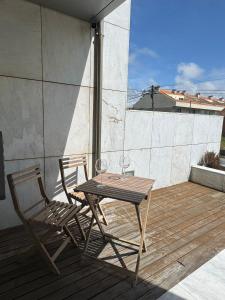 a wooden table and two chairs on a patio at Beach House - Aguda Beach - 2 bedrooms in Arcozelo