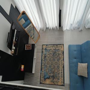 a living room with a blue couch and a rug at Cabin Athenea Sikapuk in Kejajar